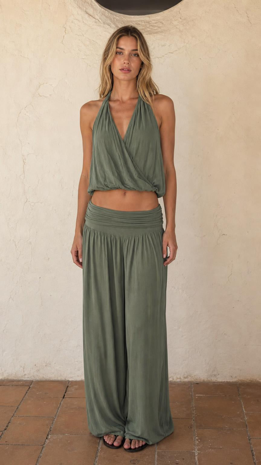 Front view of woman wearing sage green halter crop top and wide leg pants set