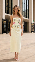 Front view of model wearing yellow floral embroidered midi dress