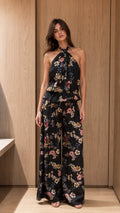 Front view of black floral halter top and wide-leg pants set on model