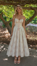 Full length view of woman wearing white floral corset midi dress outdoors