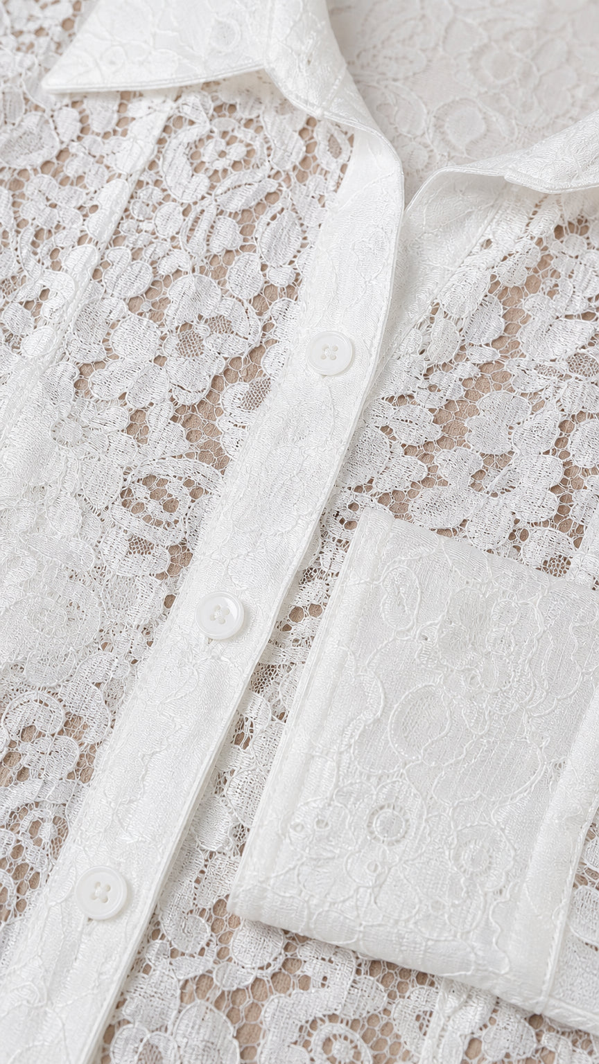 Close-up detail of white floral lace fabric and button placket