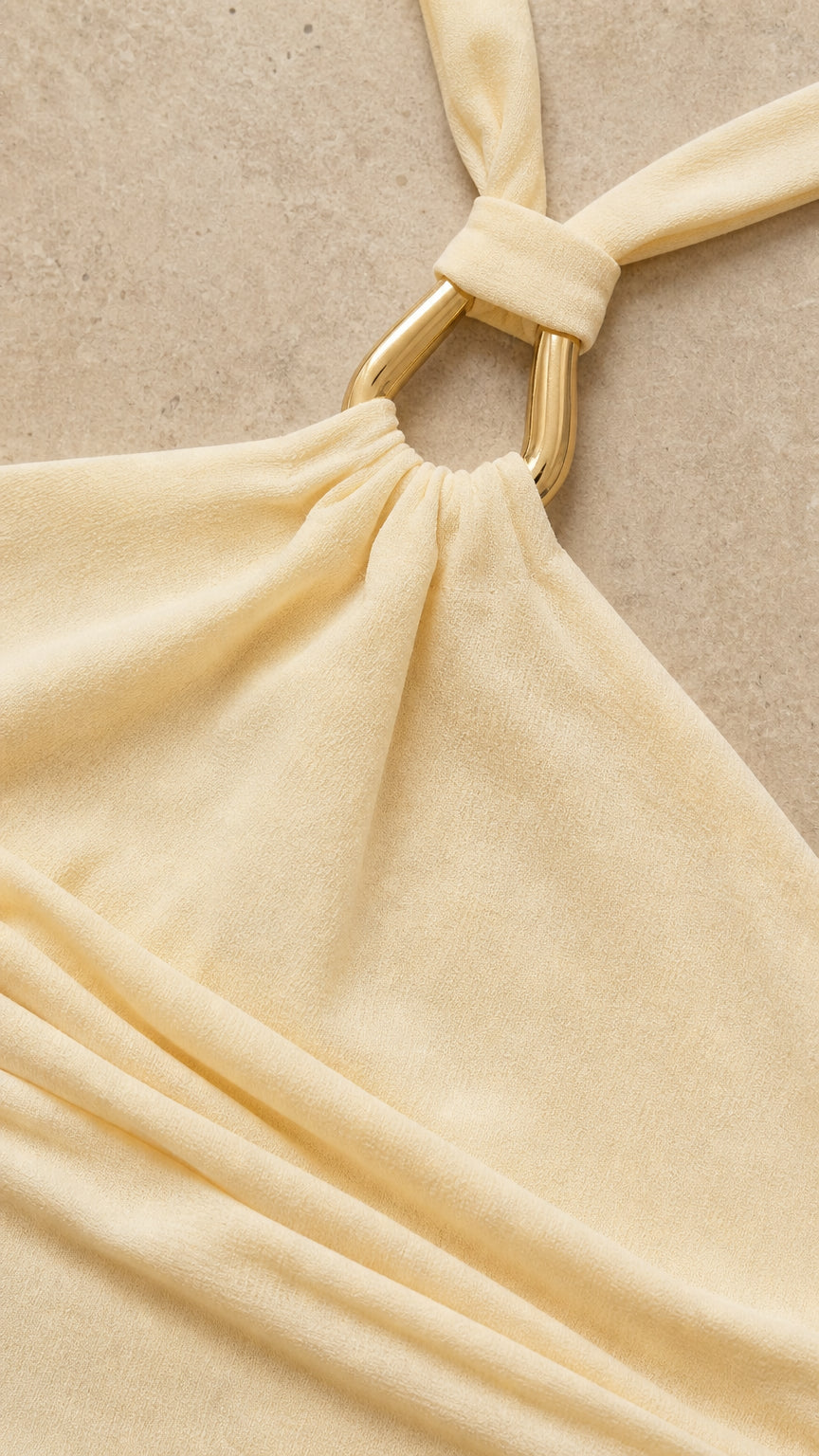 Close up of metal ring halter neck detail on yellow dress