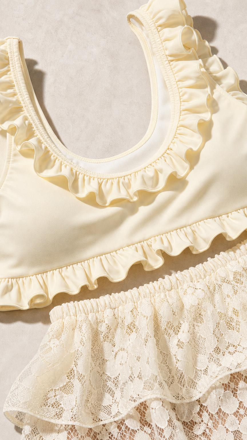 Close-up detail of ivory ruffled neckline and lace waistband